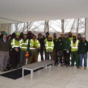 A group of people in yellow vests standing next to each other.