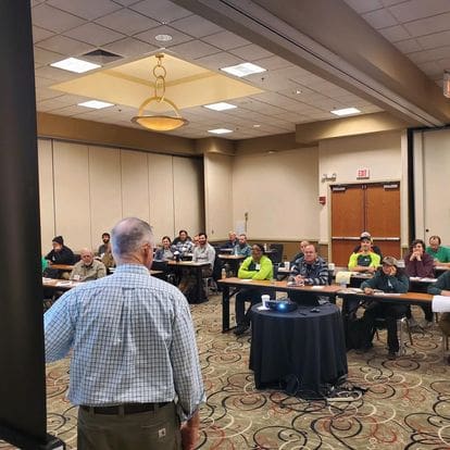 Business meeting with attendees seated at tables.