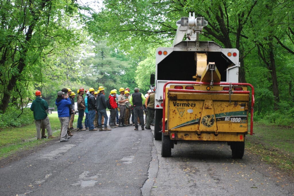 Tree crew with wood chipper in woods.