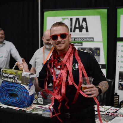 Man with red sunglasses holding climbing rope.