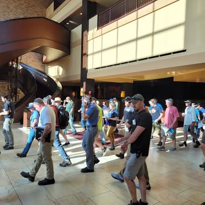 People walking in hotel lobby near staircase.