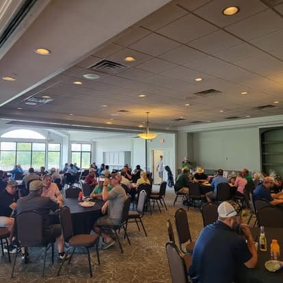 People seated at tables in a large room.