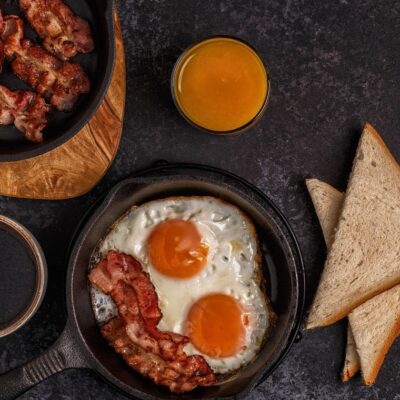 Breakfast with bacon, eggs, toast, and juice.