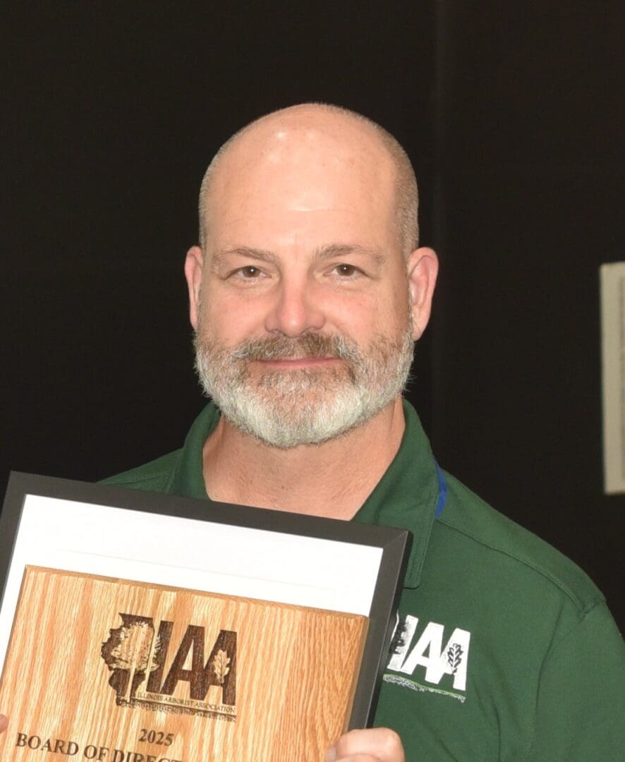 Man holding a wooden award plaque.