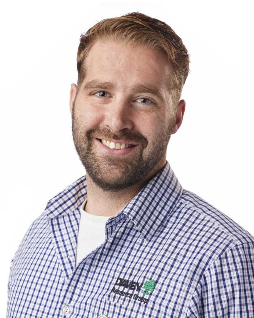 Smiling man in checkered shirt, white background.